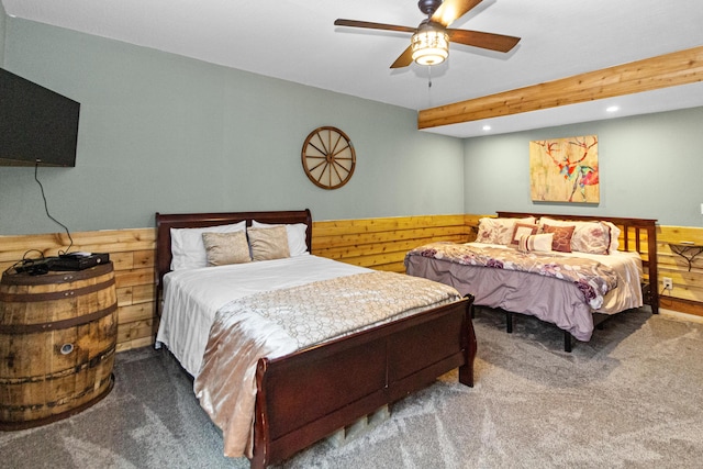 bedroom with carpet, ceiling fan, and wood walls