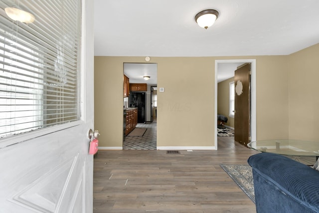 foyer entrance with wood finished floors and baseboards