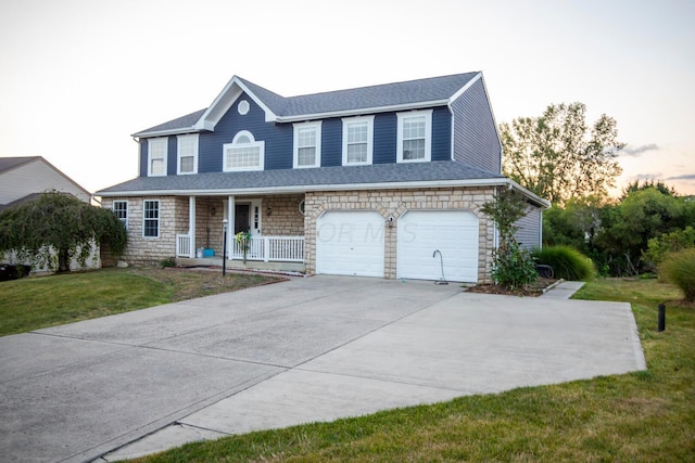 view of front facade featuring a porch, a garage, and a lawn