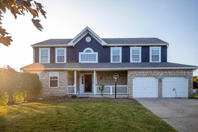 view of front of home featuring a porch, a garage, and a front yard