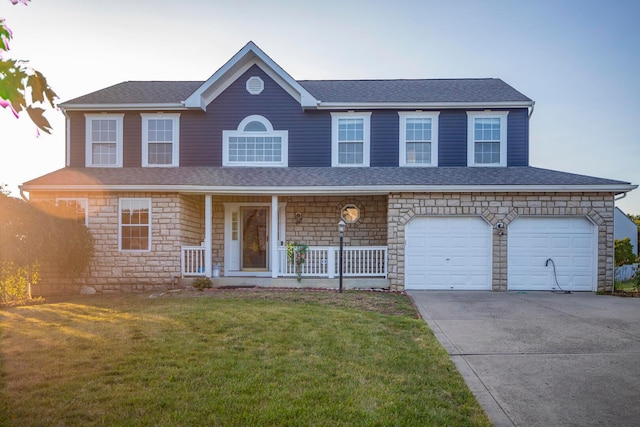 view of front of property featuring a garage, a front yard, and covered porch