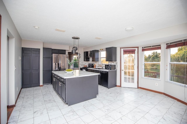 kitchen featuring sink, backsplash, black appliances, a kitchen island, and decorative light fixtures