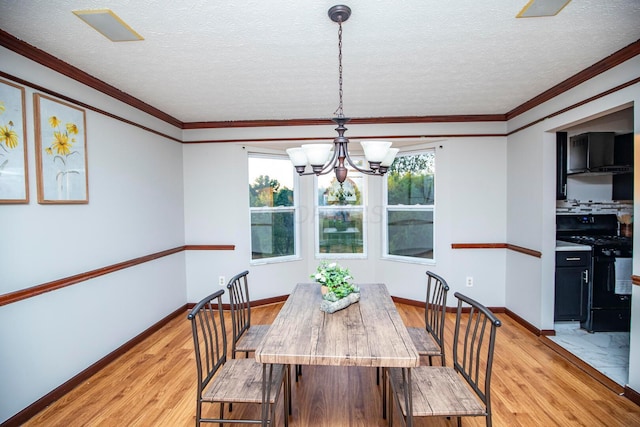 dining space featuring an inviting chandelier, ornamental molding, light hardwood / wood-style floors, and a textured ceiling