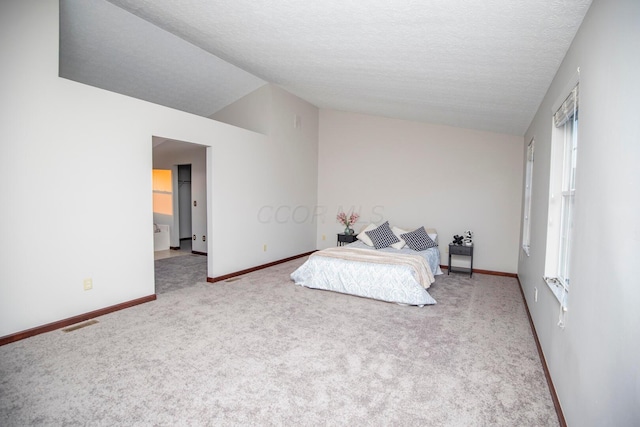 bedroom featuring lofted ceiling, carpet, and a textured ceiling