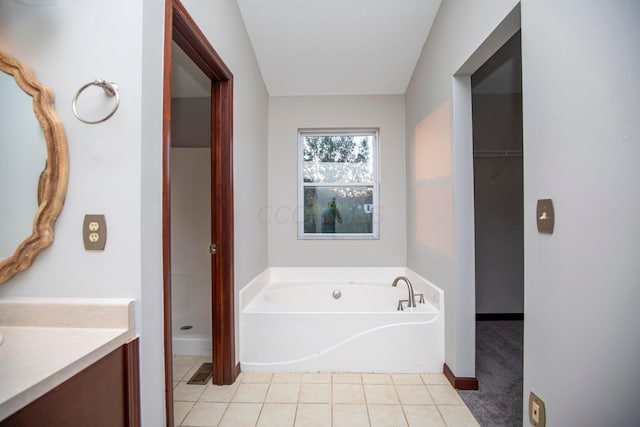 bathroom with a tub to relax in, vanity, tile patterned flooring, and a textured ceiling