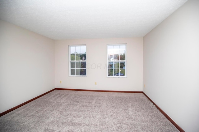 carpeted spare room featuring a textured ceiling