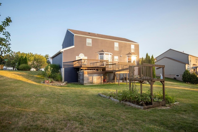 back of house with a wooden deck and a lawn