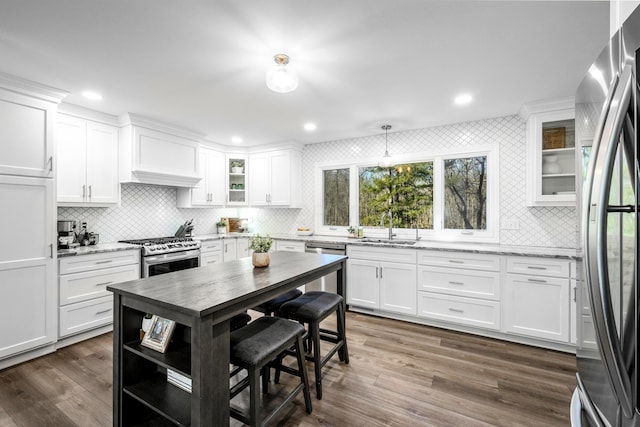 kitchen featuring stainless steel appliances, light stone countertops, and white cabinets