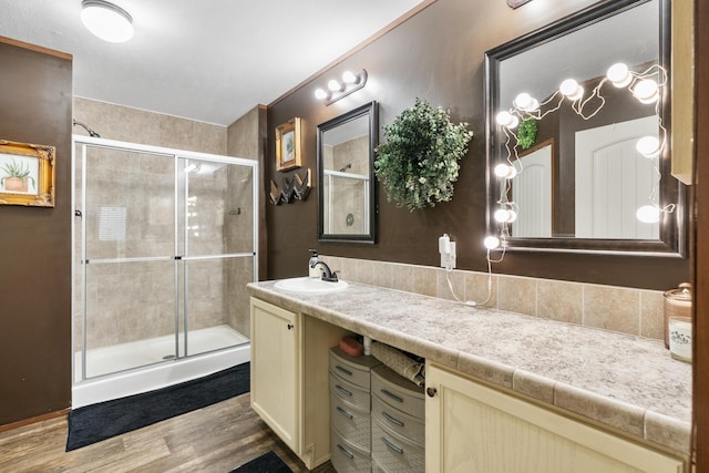 bathroom with vanity, wood-type flooring, and a shower with door