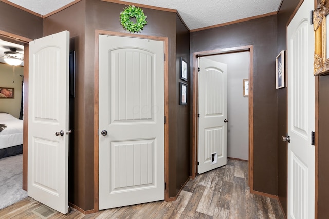 hallway featuring wood-type flooring and a textured ceiling