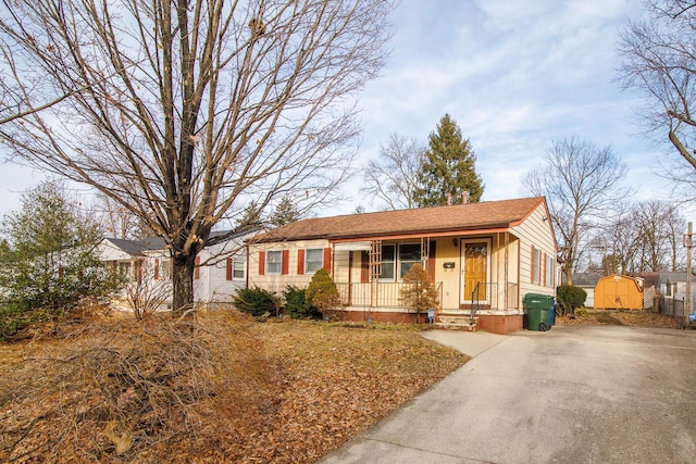 ranch-style house with covered porch and a storage shed