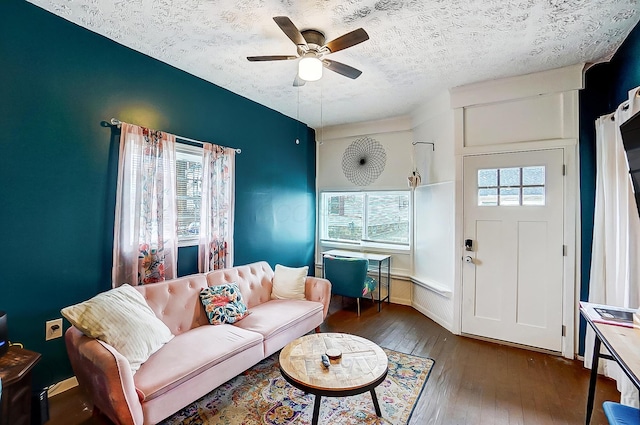 living room with dark hardwood / wood-style floors, a wealth of natural light, a textured ceiling, and ceiling fan