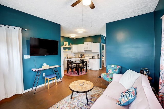 living room featuring ceiling fan, hardwood / wood-style flooring, sink, and a textured ceiling