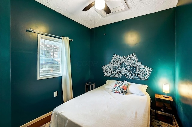 bedroom with ceiling fan and a textured ceiling