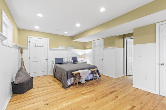 bedroom featuring wainscoting, light wood-style flooring, and recessed lighting