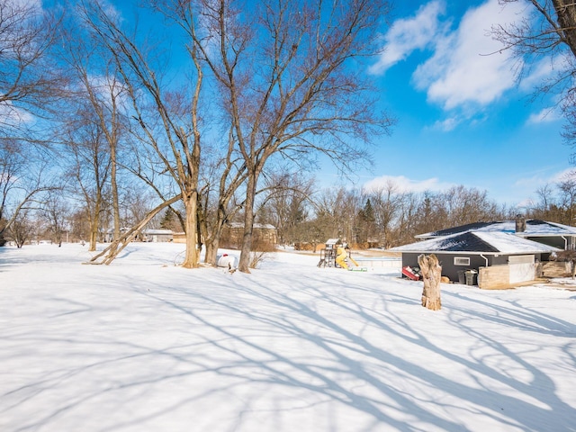 yard layered in snow featuring a playground