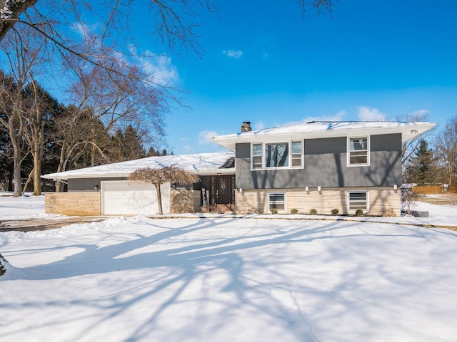 tri-level home with a garage and a chimney