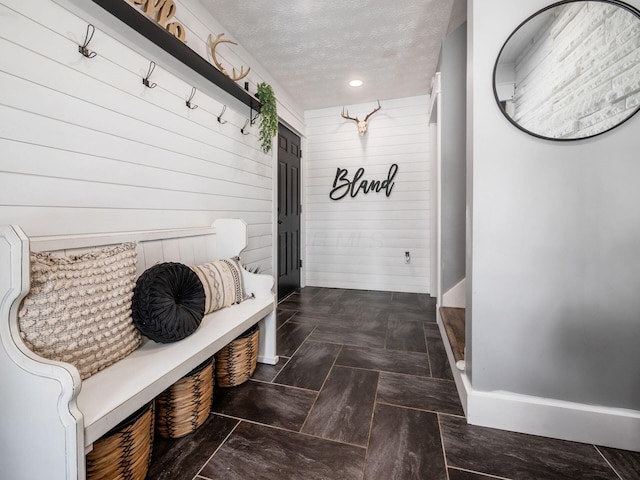 mudroom featuring baseboards, a textured ceiling, and recessed lighting