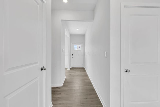 corridor featuring wood finished floors, baseboards, and recessed lighting