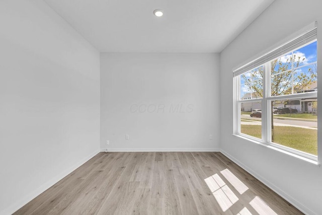 spare room featuring recessed lighting, light wood-style flooring, and baseboards