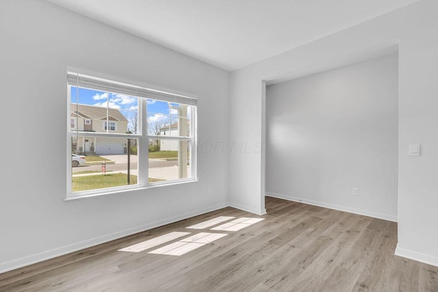 empty room with baseboards and wood finished floors