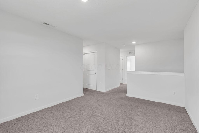 empty room with baseboards, visible vents, carpet, and recessed lighting