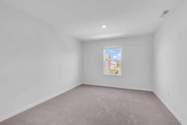 carpeted spare room featuring baseboards, visible vents, and recessed lighting