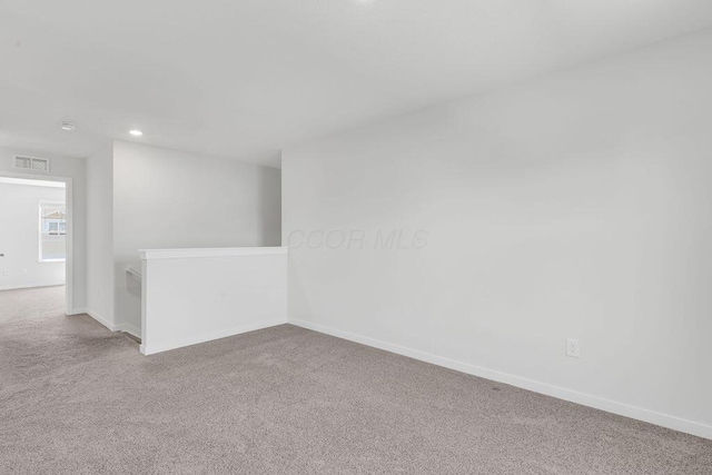 carpeted spare room featuring visible vents, baseboards, and recessed lighting