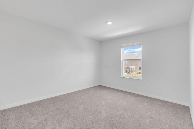 spare room featuring recessed lighting, baseboards, and carpet