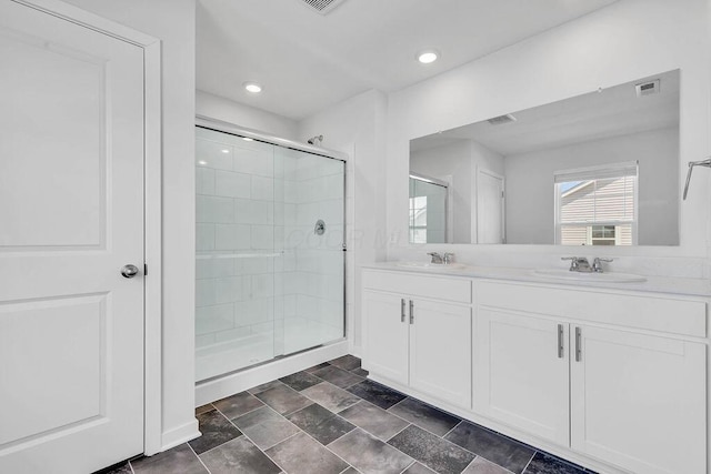 full bath featuring a shower stall, a sink, double vanity, stone finish floor, and visible vents