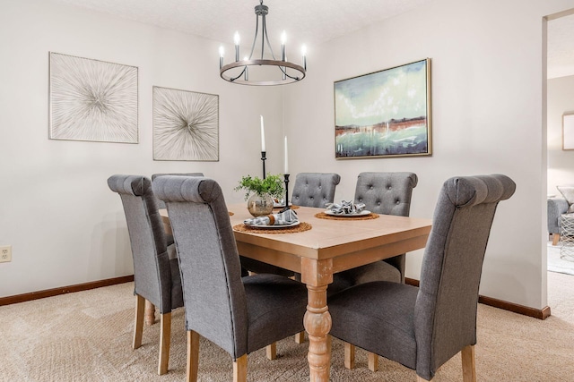 dining room with light colored carpet, an inviting chandelier, and baseboards