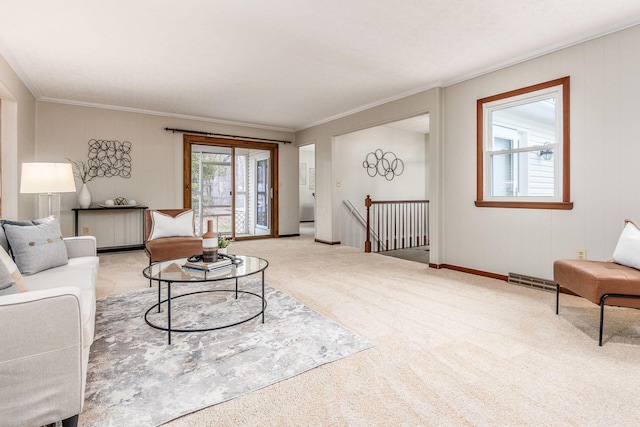 carpeted living area with visible vents, baseboards, radiator, and crown molding