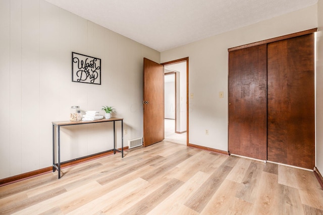 bedroom with visible vents, baseboards, and wood finished floors