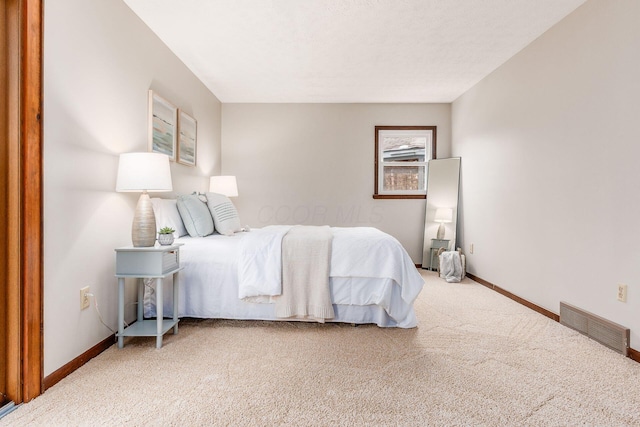 carpeted bedroom with baseboards and visible vents