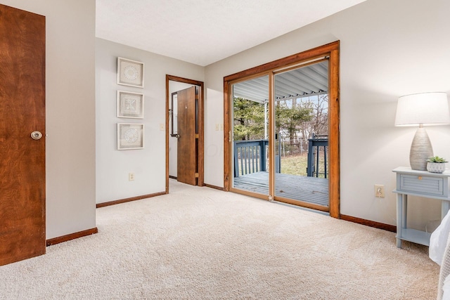 interior space featuring baseboards, carpet, and access to exterior