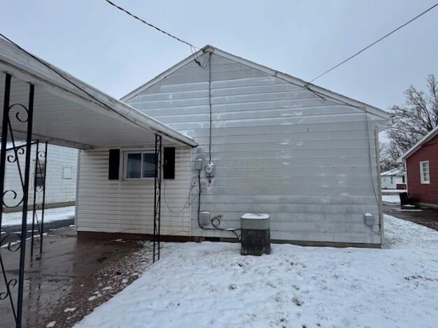 snow covered property featuring a carport