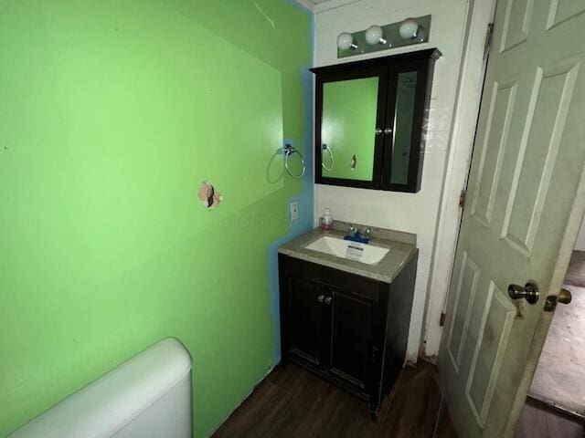 bathroom featuring vanity, wood-type flooring, and toilet