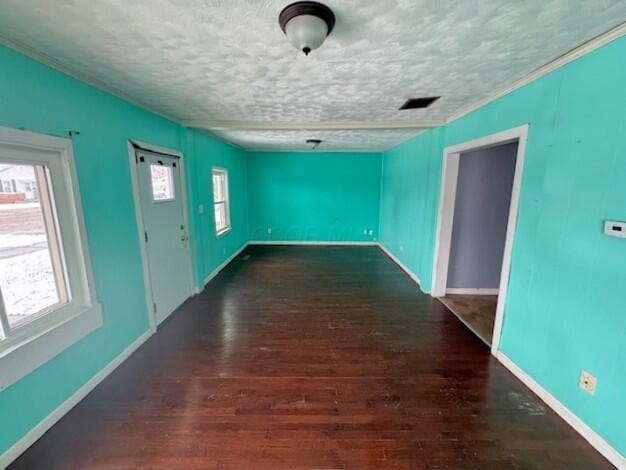 unfurnished room with dark hardwood / wood-style flooring and a textured ceiling