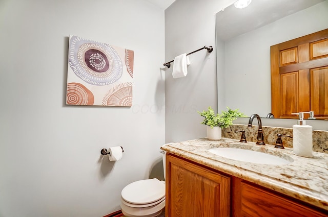 bathroom featuring toilet and vanity