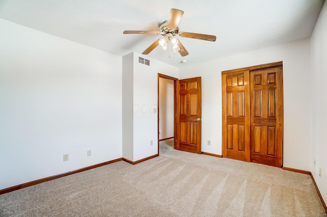 unfurnished bedroom featuring light colored carpet and ceiling fan