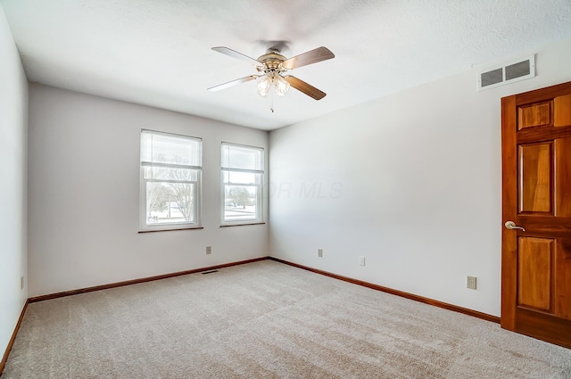 carpeted spare room with ceiling fan