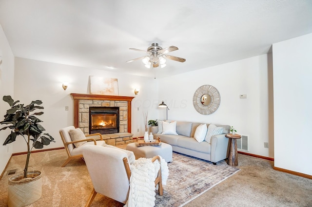 living room featuring ceiling fan, light colored carpet, and a stone fireplace