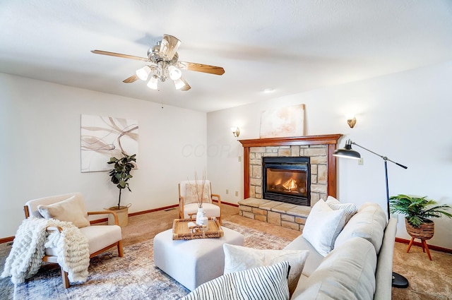 carpeted living room featuring ceiling fan and a stone fireplace