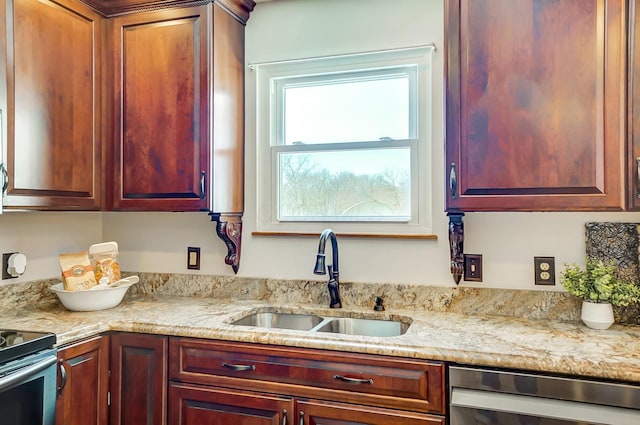 kitchen with appliances with stainless steel finishes, sink, and light stone countertops