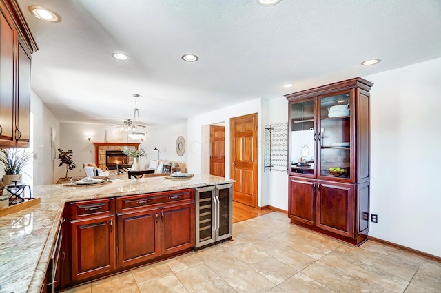 kitchen featuring pendant lighting, beverage cooler, and light stone counters