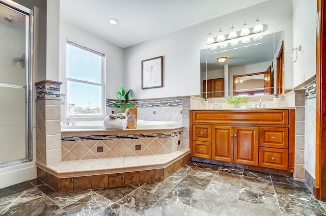 bathroom with tile walls, vanity, and shower with separate bathtub