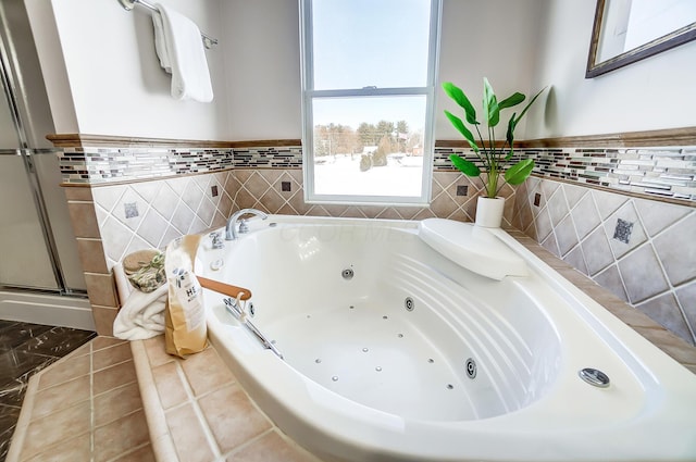 bathroom featuring tile patterned flooring, tile walls, and a bathing tub