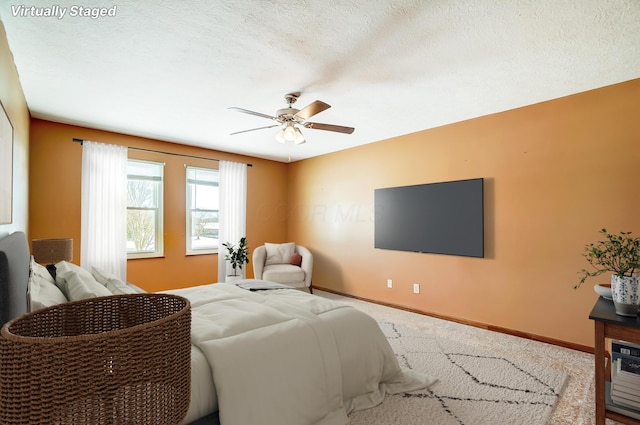 bedroom featuring a textured ceiling, carpet flooring, and ceiling fan