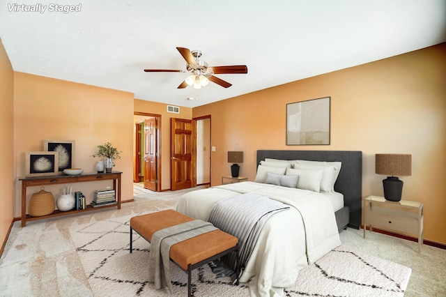 bedroom featuring light colored carpet and ceiling fan