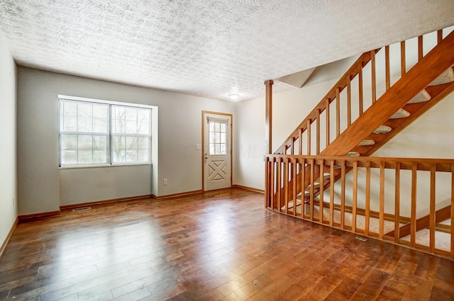 entrance foyer with hardwood / wood-style floors and a textured ceiling